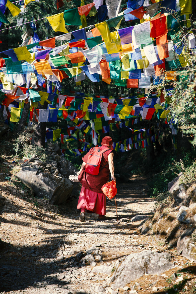 Một vị sư đi bộ dưới những lá cờ cầu nguyện Tây Tạng
